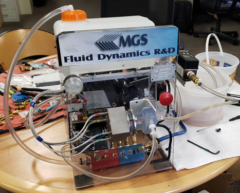 MGS made three different cooling fixture designs. Experiments were carried out on the cooling of the copper pin, isobar, and bubbler, and then the simulation results were compared with the experiment values. First, the CFD board was used in the actual experiment to measure the cooling rate, temperature, and pressure. As shown in Fig. 1, we can see the CFD board simulated cooling design configuration diagram. Fig. 2 is the fixture that houses three engineered cooling methods. The cooling fixture build was made up of 3D printed metal, tool steel, and SLA; The cooling fixture used cartridge heaters to supply heat to the fixture, and thermocouples were used to measure the temperature change of the heat block.